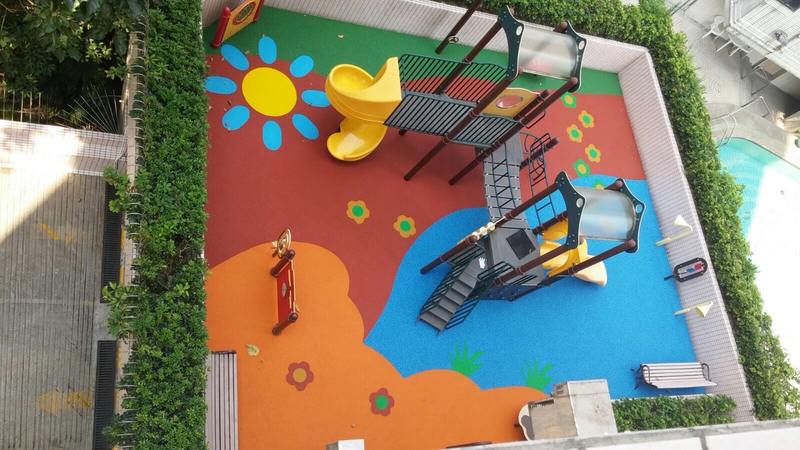 Aerial view of colourful playground flooring and play equipment