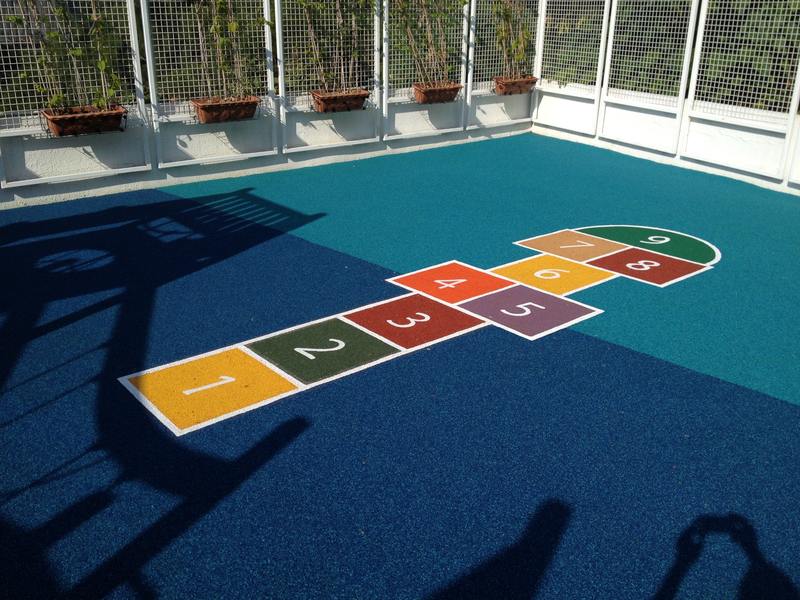 Colourful hopscotch markings on a blue surface