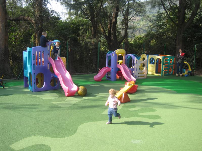 Green playground flooring and a slide